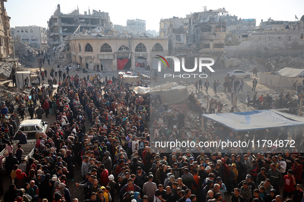 Palestinians wait in a queue to receive bread outside a bakery in Khan Yunis, on November 20, 2024, amid the ongoing war between Israel and...