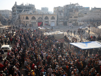 Palestinians wait in a queue to receive bread outside a bakery in Khan Yunis, on November 20, 2024, amid the ongoing war between Israel and...