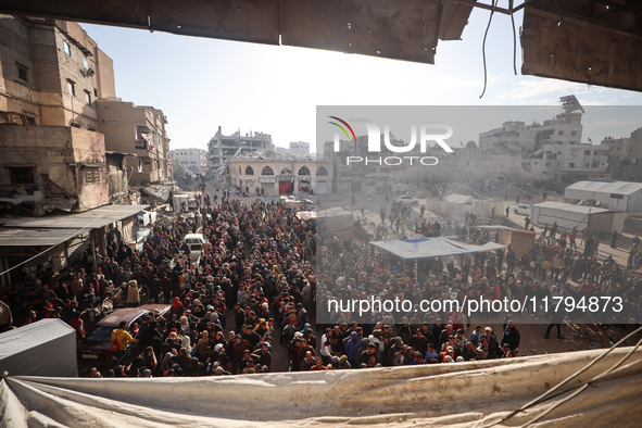 Palestinians wait in a queue to receive bread outside a bakery in Khan Yunis, on November 20, 2024, amid the ongoing war between Israel and...