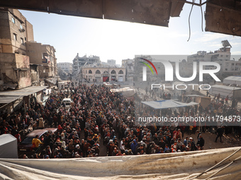 Palestinians wait in a queue to receive bread outside a bakery in Khan Yunis, on November 20, 2024, amid the ongoing war between Israel and...