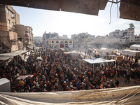 Palestinians wait in a queue to receive bread outside a bakery in Khan Yunis, on November 20, 2024, amid the ongoing war between Israel and...