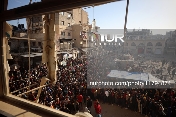 Palestinians wait in a queue to receive bread outside a bakery in Khan Yunis, on November 20, 2024, amid the ongoing war between Israel and...