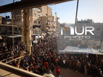 Palestinians wait in a queue to receive bread outside a bakery in Khan Yunis, on November 20, 2024, amid the ongoing war between Israel and...