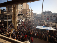 Palestinians wait in a queue to receive bread outside a bakery in Khan Yunis, on November 20, 2024, amid the ongoing war between Israel and...