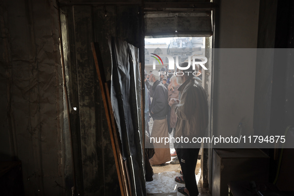 Palestinians wait in a queue to receive bread outside a bakery in Khan Yunis, on November 20, 2024, amid the ongoing war between Israel and...