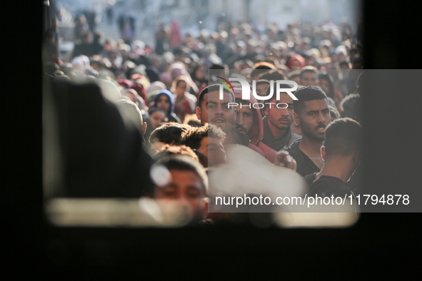 Palestinians wait in a queue to receive bread outside a bakery in Khan Yunis, on November 20, 2024, amid the ongoing war between Israel and...