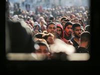 Palestinians wait in a queue to receive bread outside a bakery in Khan Yunis, on November 20, 2024, amid the ongoing war between Israel and...