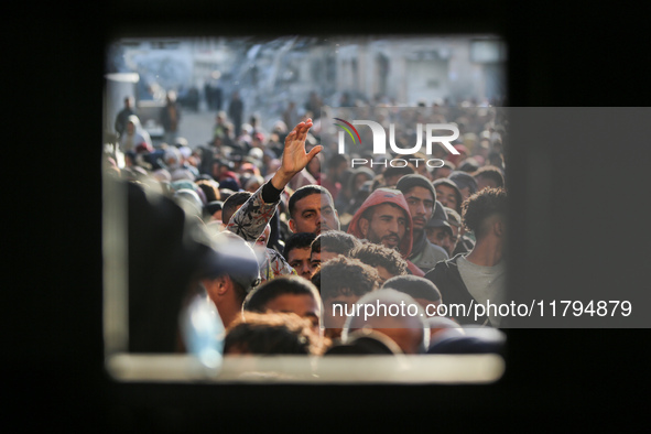 Palestinians wait in a queue to receive bread outside a bakery in Khan Yunis, on November 20, 2024, amid the ongoing war between Israel and...