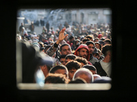 Palestinians wait in a queue to receive bread outside a bakery in Khan Yunis, on November 20, 2024, amid the ongoing war between Israel and...