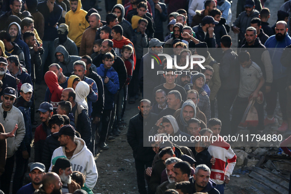 Palestinians wait in a queue to receive bread outside a bakery in Khan Yunis, on November 20, 2024, amid the ongoing war between Israel and...