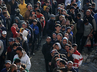 Palestinians wait in a queue to receive bread outside a bakery in Khan Yunis, on November 20, 2024, amid the ongoing war between Israel and...