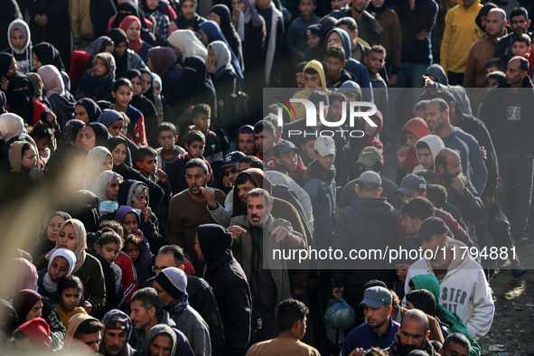 Palestinians wait in a queue to receive bread outside a bakery in Khan Yunis, on November 20, 2024, amid the ongoing war between Israel and...