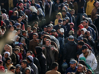 Palestinians wait in a queue to receive bread outside a bakery in Khan Yunis, on November 20, 2024, amid the ongoing war between Israel and...