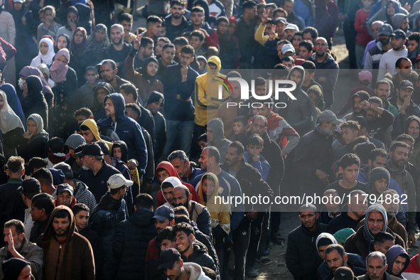 Palestinians wait in a queue to receive bread outside a bakery in Khan Yunis, on November 20, 2024, amid the ongoing war between Israel and...