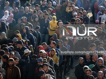 Palestinians wait in a queue to receive bread outside a bakery in Khan Yunis, on November 20, 2024, amid the ongoing war between Israel and...