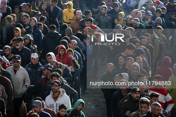 Palestinians wait in a queue to receive bread outside a bakery in Khan Yunis, on November 20, 2024, amid the ongoing war between Israel and...