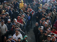 Palestinians wait in a queue to receive bread outside a bakery in Khan Yunis, on November 20, 2024, amid the ongoing war between Israel and...