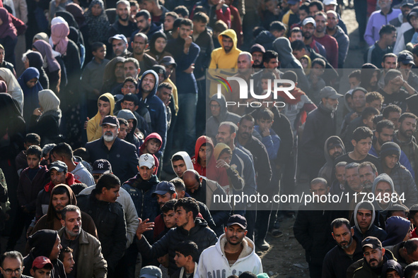 Palestinians wait in a queue to receive bread outside a bakery in Khan Yunis, on November 20, 2024, amid the ongoing war between Israel and...