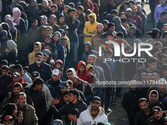 Palestinians wait in a queue to receive bread outside a bakery in Khan Yunis, on November 20, 2024, amid the ongoing war between Israel and...