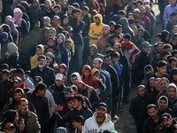 Palestinians wait in a queue to receive bread outside a bakery in Khan Yunis, on November 20, 2024, amid the ongoing war between Israel and...