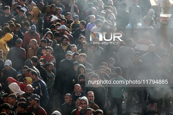 Palestinians wait in a queue to receive bread outside a bakery in Khan Yunis, on November 20, 2024, amid the ongoing war between Israel and...