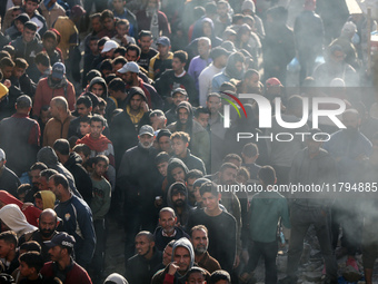 Palestinians wait in a queue to receive bread outside a bakery in Khan Yunis, on November 20, 2024, amid the ongoing war between Israel and...