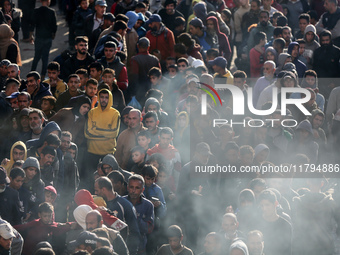 Palestinians wait in a queue to receive bread outside a bakery in Khan Yunis, on November 20, 2024, amid the ongoing war between Israel and...