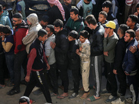 Palestinians wait in a queue to receive bread outside a bakery in Khan Yunis, on November 20, 2024, amid the ongoing war between Israel and...