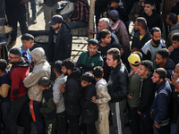 Palestinians wait in a queue to receive bread outside a bakery in Khan Yunis, on November 20, 2024, amid the ongoing war between Israel and...