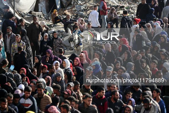 Palestinians wait in a queue to receive bread outside a bakery in Khan Yunis, on November 20, 2024, amid the ongoing war between Israel and...