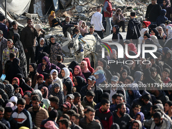 Palestinians wait in a queue to receive bread outside a bakery in Khan Yunis, on November 20, 2024, amid the ongoing war between Israel and...