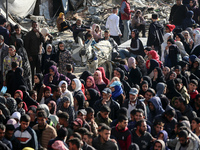 Palestinians wait in a queue to receive bread outside a bakery in Khan Yunis, on November 20, 2024, amid the ongoing war between Israel and...