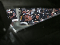 Palestinians wait in a queue to receive bread outside a bakery in Khan Yunis, on November 20, 2024, amid the ongoing war between Israel and...