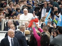 Pope Francis waves as he arrives for his weekly general audience in St. Peter's Square at The Vatican, on November 20, 2024. (