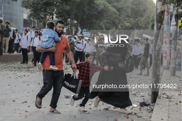 Commuters pass by a road during a clash in Dhaka, Bangladesh, on November 20, 2024. 