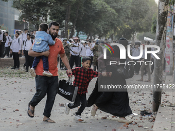 Commuters pass by a road during a clash in Dhaka, Bangladesh, on November 20, 2024. (