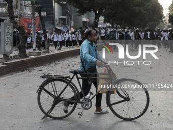 Commuters pass by a road during a clash in Dhaka, Bangladesh, on November 20, 2024. (