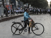 Commuters pass by a road during a clash in Dhaka, Bangladesh, on November 20, 2024. (