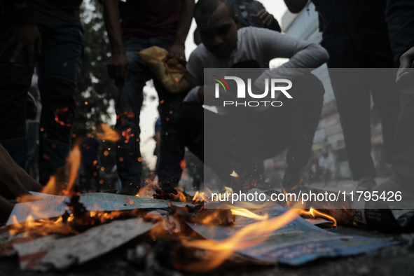 A commuter inhales fire smoke to counteract tear gas during a clash in Dhaka, Bangladesh, on November 20, 2024. 