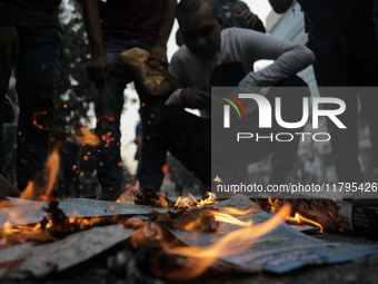 A commuter inhales fire smoke to counteract tear gas during a clash in Dhaka, Bangladesh, on November 20, 2024. (