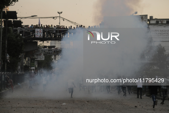 A student runs through the smoke of tear gas during a clash in Dhaka, Bangladesh, on November 20, 2024. 