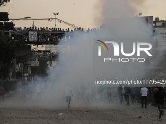 A student runs through the smoke of tear gas during a clash in Dhaka, Bangladesh, on November 20, 2024. (