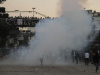 A student runs through the smoke of tear gas during a clash in Dhaka, Bangladesh, on November 20, 2024. (