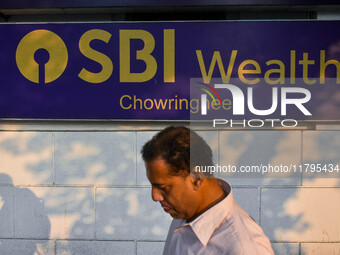 A man walks past a branch of State Bank of India Wealth Management in Kolkata, India, on October 20, 2024. (