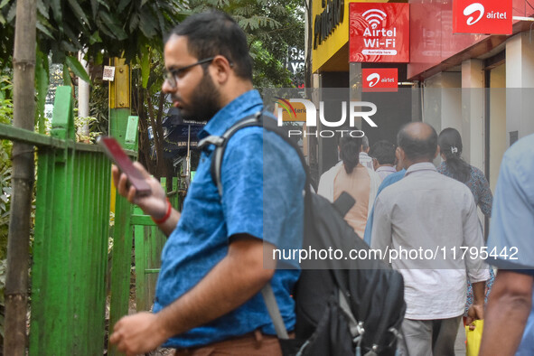 A man uses a mobile phone outside an Airtel showroom in Kolkata, India, on October 20, 2024. 