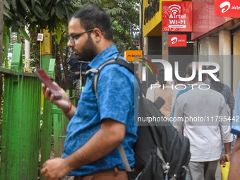 A man uses a mobile phone outside an Airtel showroom in Kolkata, India, on October 20, 2024. (