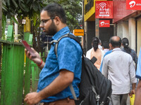 A man uses a mobile phone outside an Airtel showroom in Kolkata, India, on October 20, 2024. (