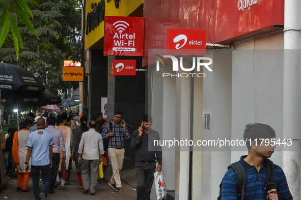 People walk past an Airtel WIFI zone in Kolkata, India, on October 20, 2024. 