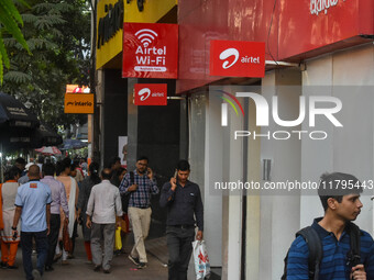 People walk past an Airtel WIFI zone in Kolkata, India, on October 20, 2024. (