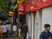 People walk past an Airtel WIFI zone in Kolkata, India, on October 20, 2024. (